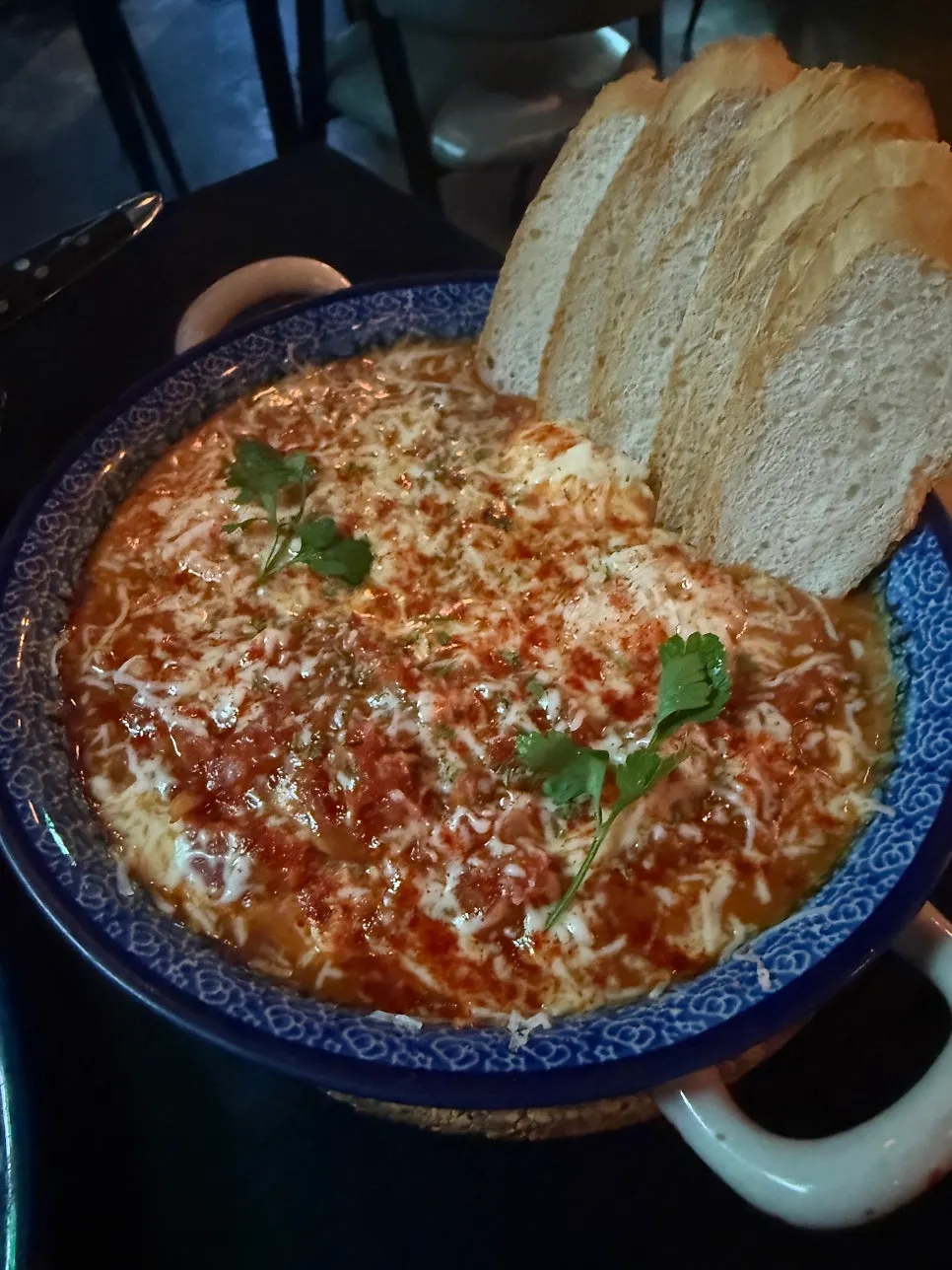 Hot pan of Egg in Hell topped with cheese and egg