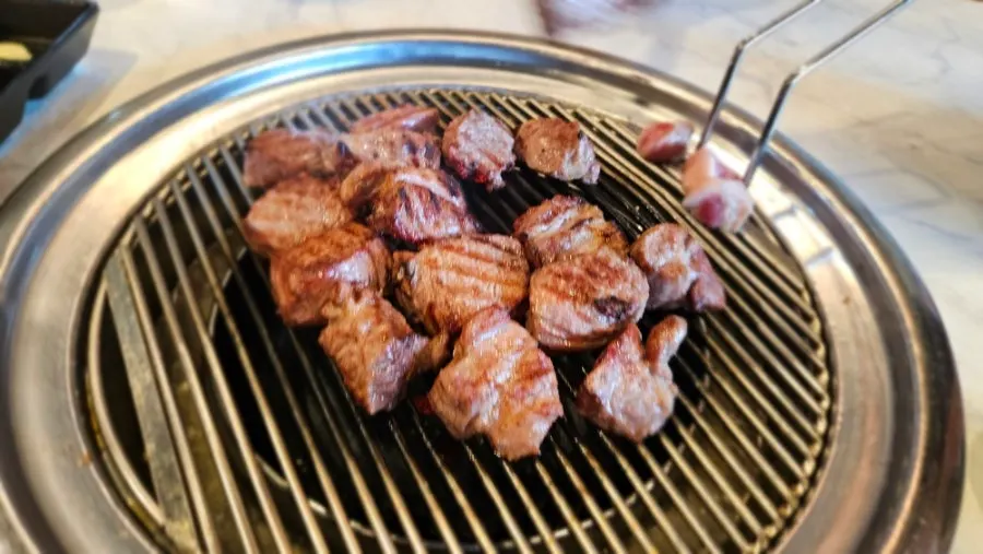 Black pork neck grilling over the charcoal brazier