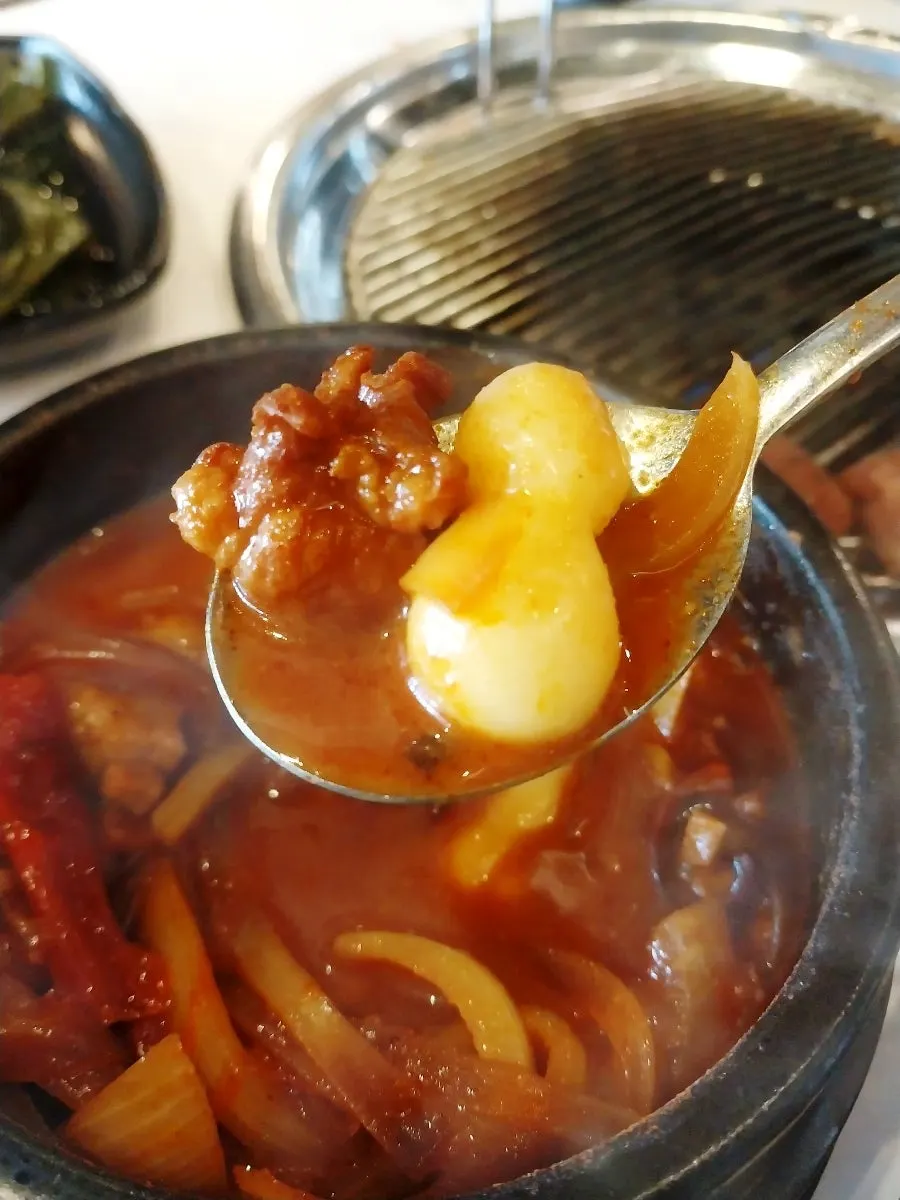 연탄구이 흑돼지와 반찬이 놓인 테이블