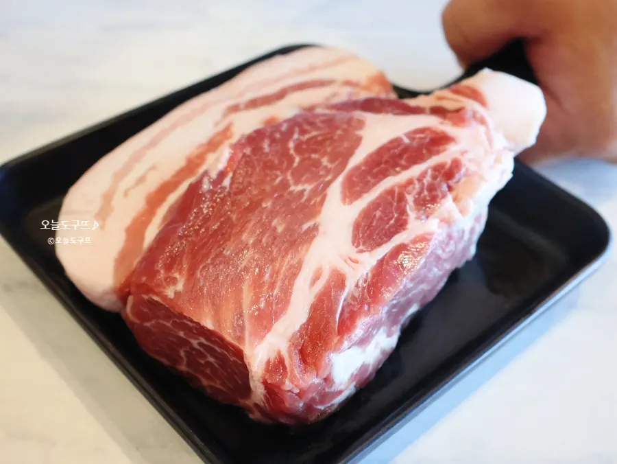 Yukbaegi set — raw black pork neck and belly on a plate