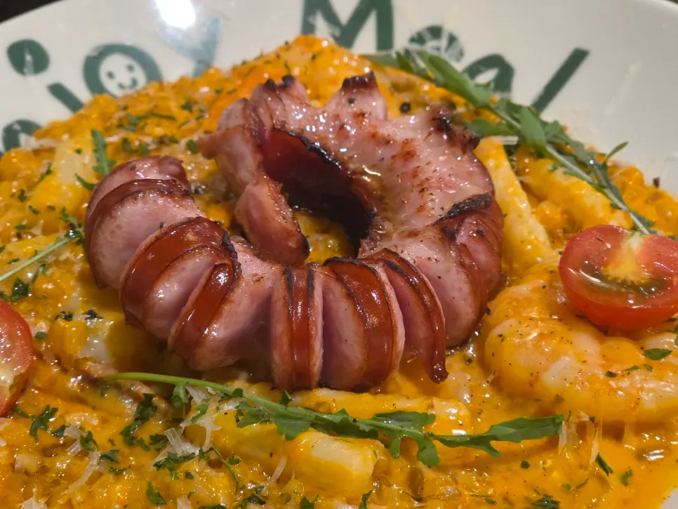 Jambalaya risotto topped with sausage, shrimp, and squid