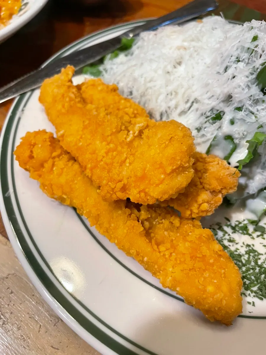 Chicken tender Caesar salad piled with snow cheese