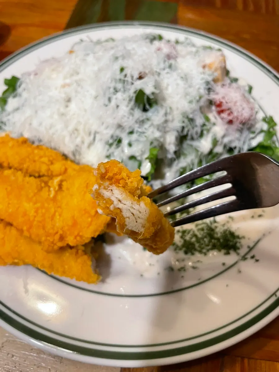 A forkful of lettuce with cheese