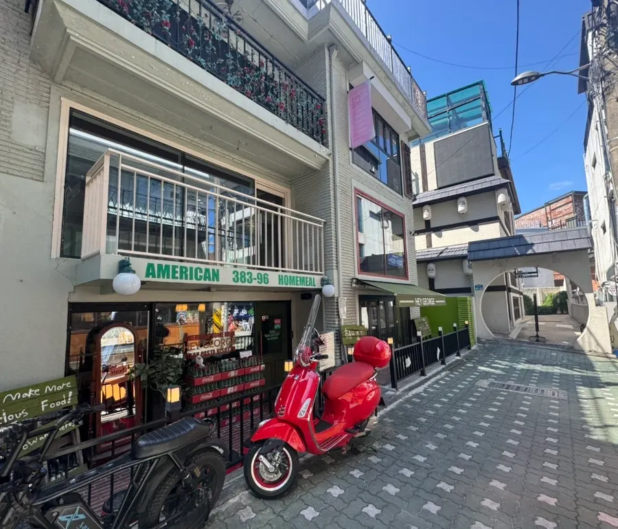 Entrance of Hey Joji with green signage and brick decor