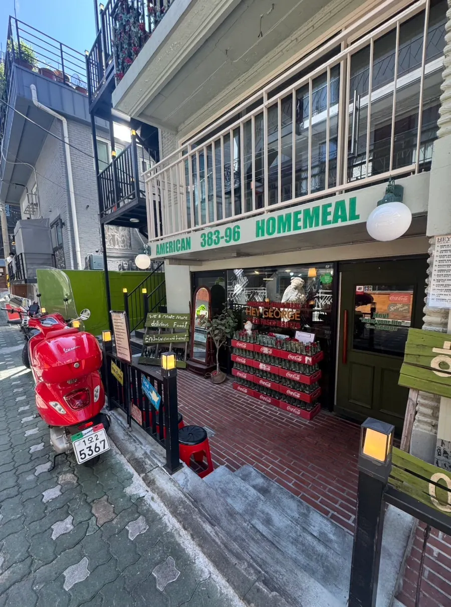 Front of Hey Joji with a red motorcycle outside