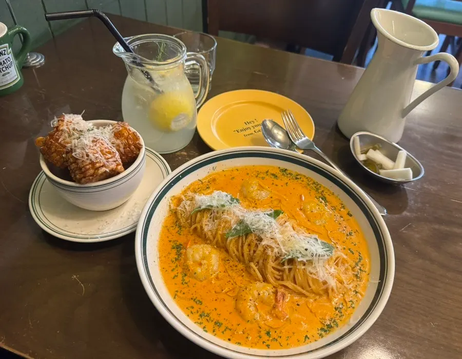 Full spread of pasta, corn ribs, and lemonade