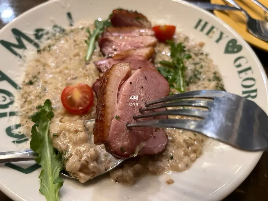 Duck steak risotto served on a plate printed with the Hey Joji logo