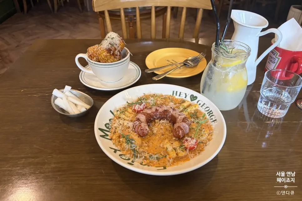 Full spread of jambalaya risotto, corn ribs, and lemonade