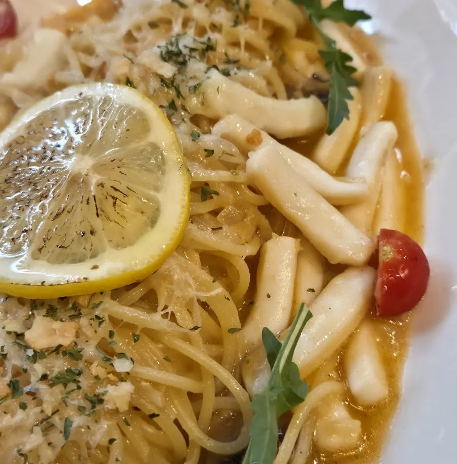 Close-up of oil pasta loaded with squid