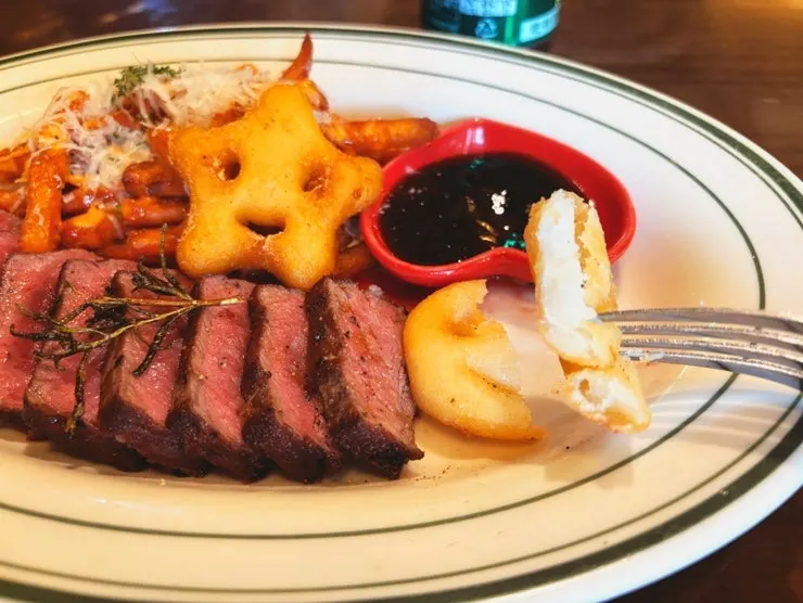 House steak served with smile-shaped fries