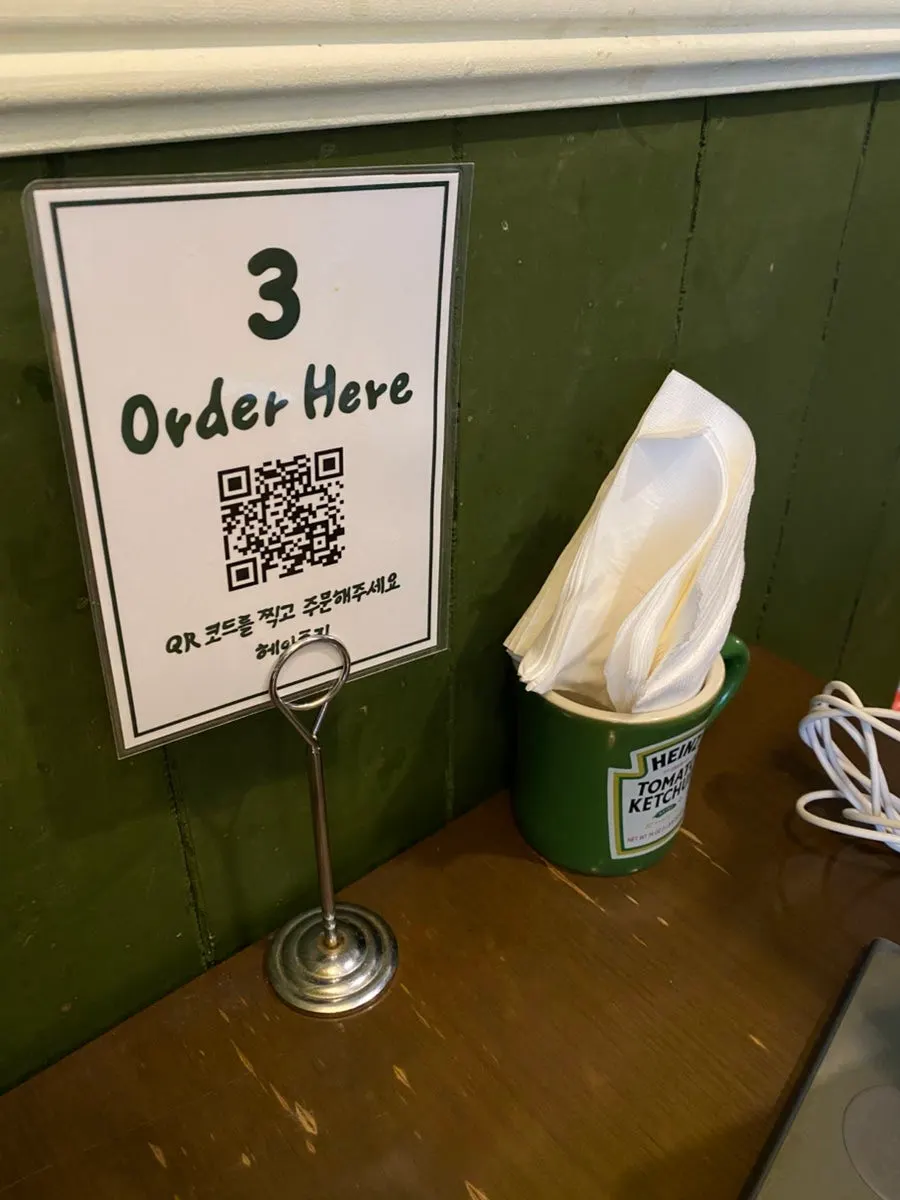 Signage placed on a table at Hey Joji