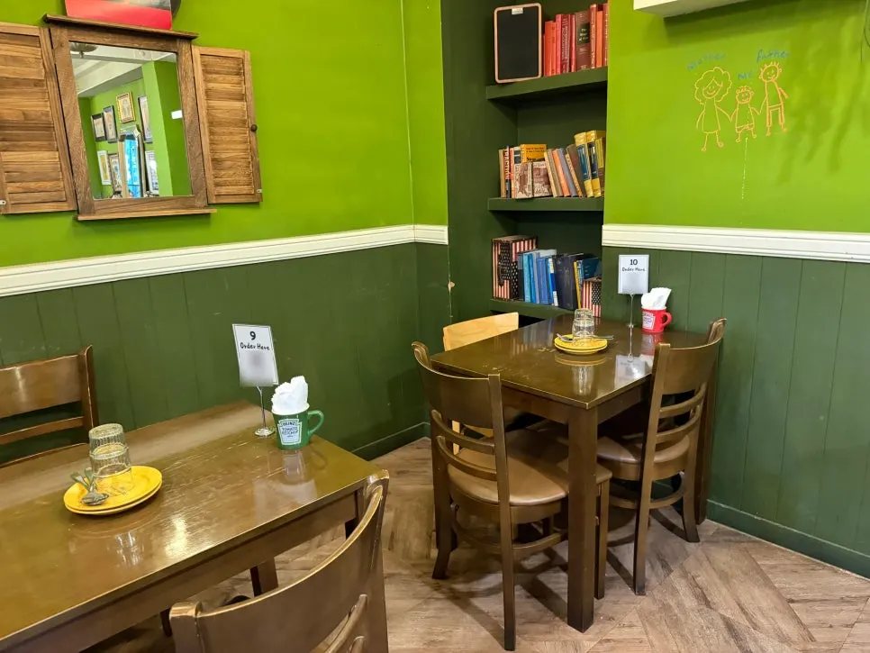 Green-toned hall with a shelf full of books