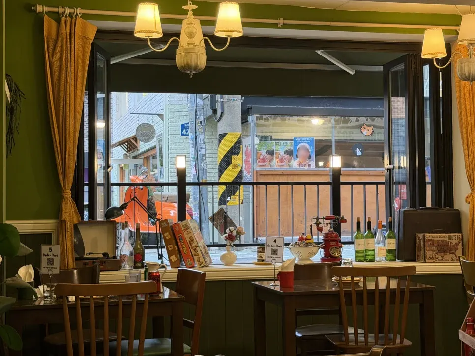 Window seat with a view of the Yeonnam-dong alley through floor-to-ceiling glass