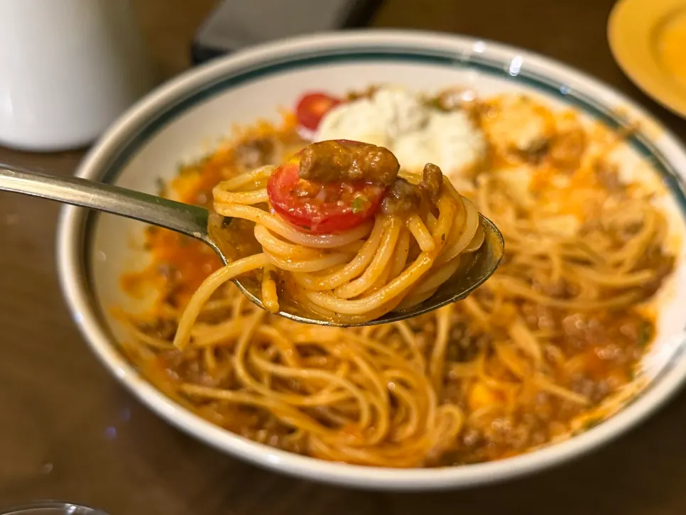 A bite of pasta mixed with burrata and tomato sauce