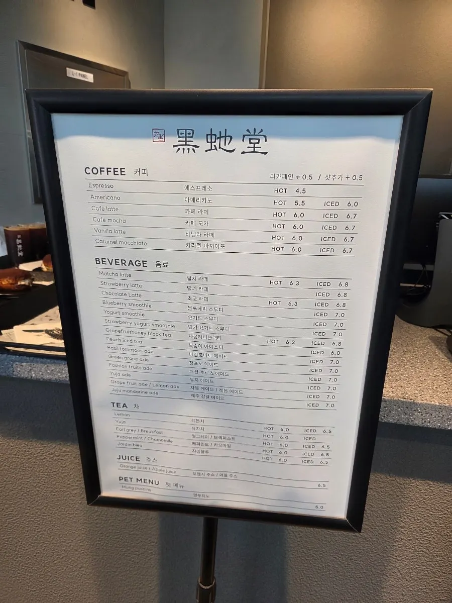 Heuksadang menu board listing coffee, lattes, smoothies, and ades
