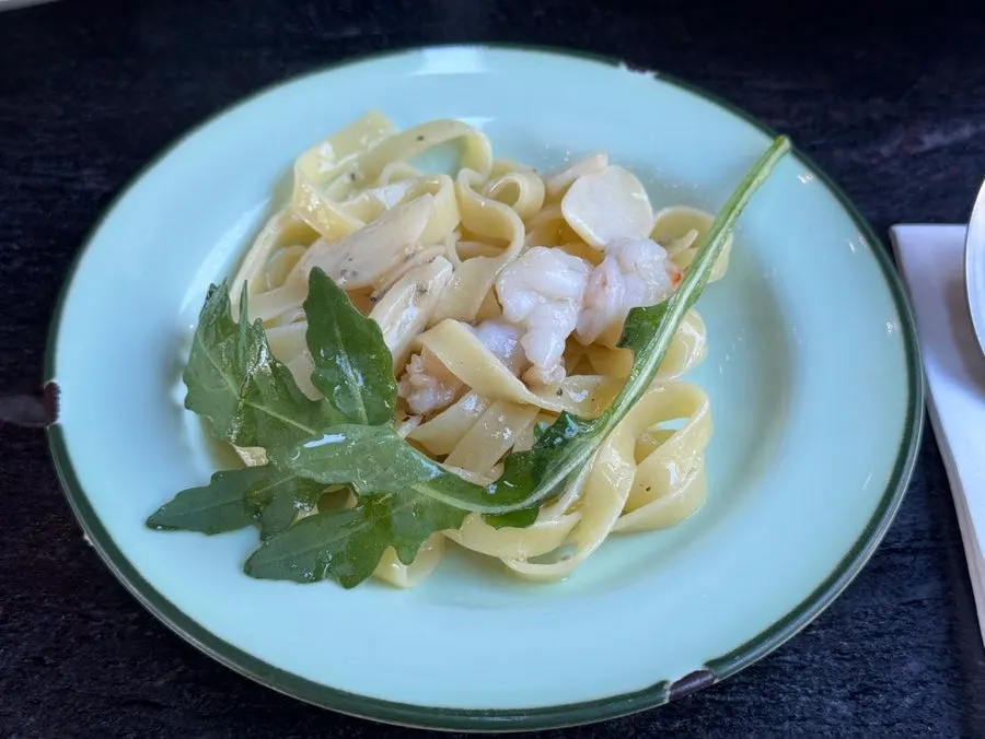 蟹肉とルッコラがのったパスタのクローズアップ