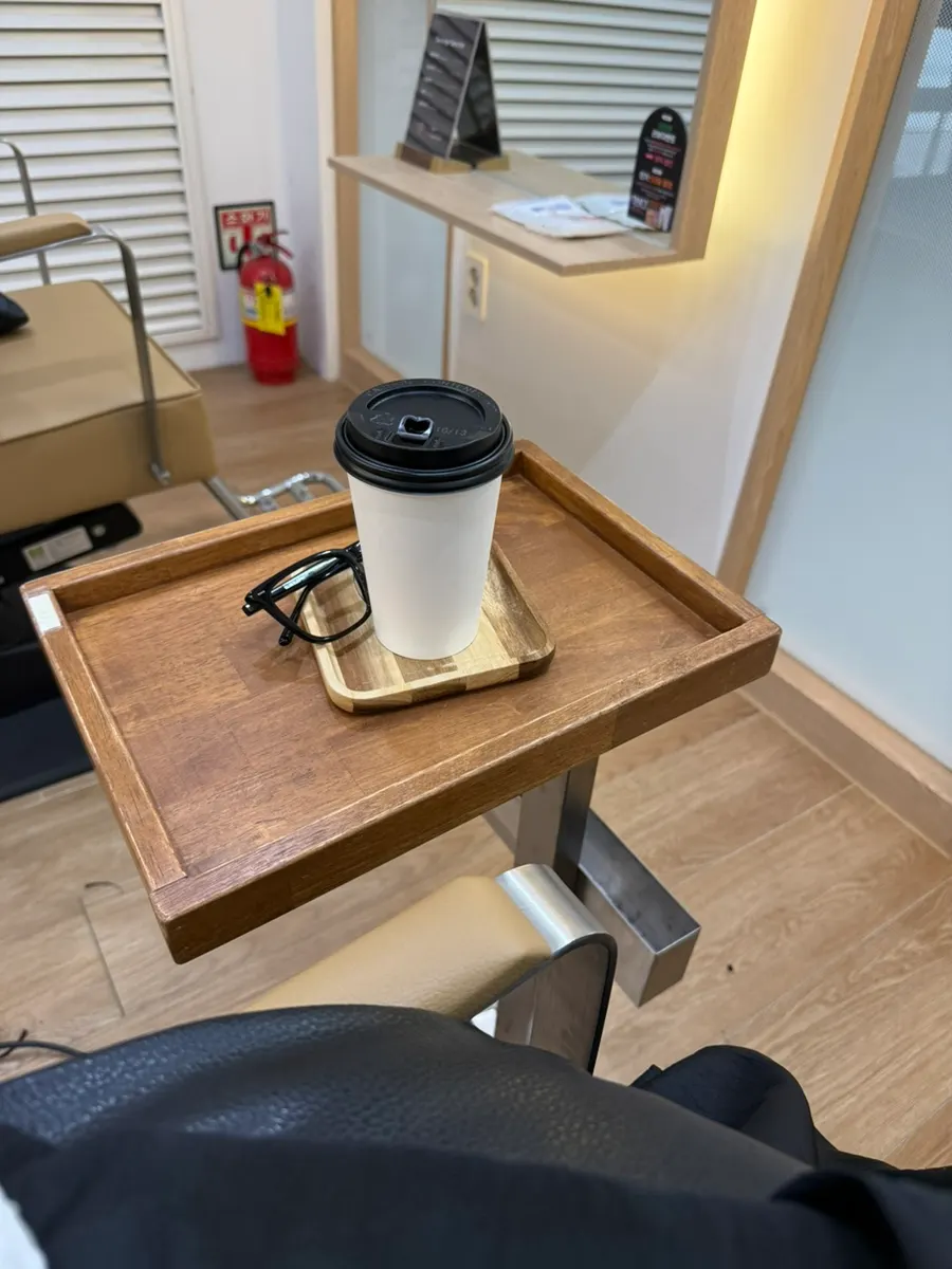 Side table with a drink placed next to the styling chair
