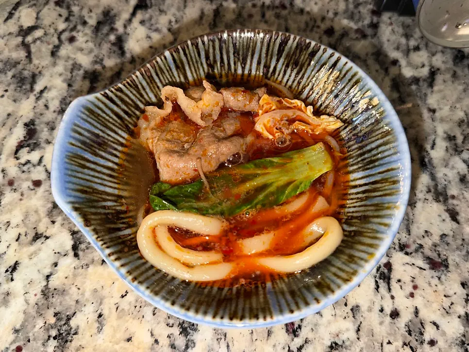 Udon noodles inside the mala hot pot broth