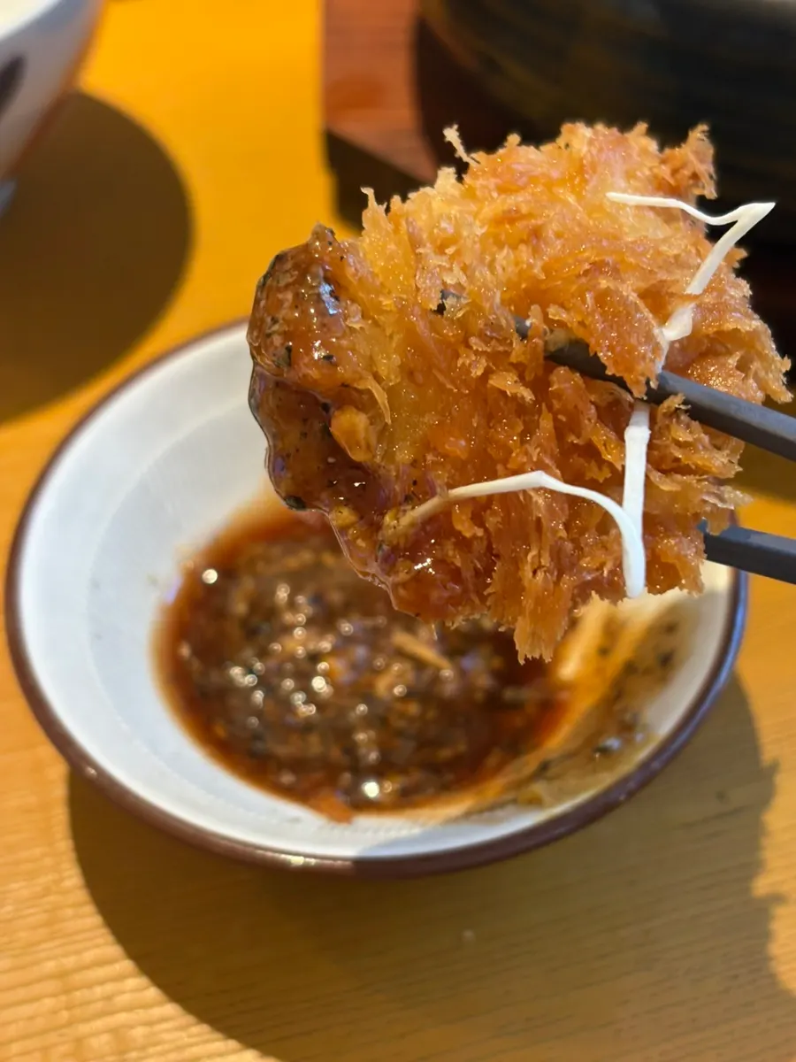 Miếng roseu katsu chấm vào sốt mè tự giã