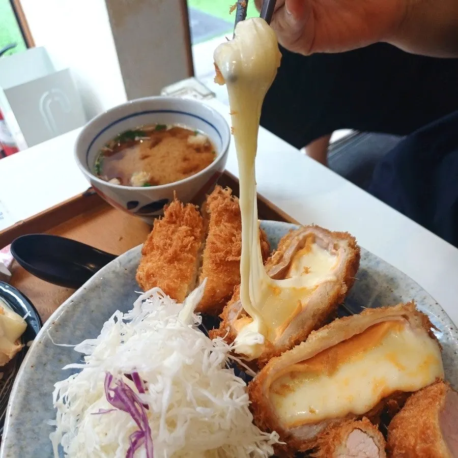 A piece of cheese katsu with cheese stretching out