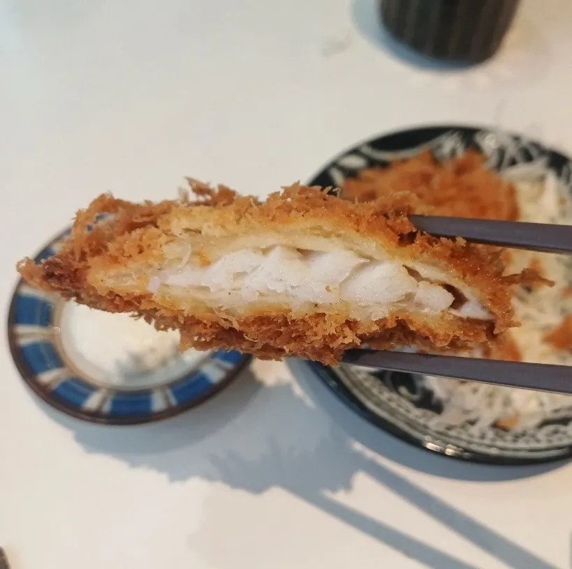 Cross-section of fish katsu dipped in sauce