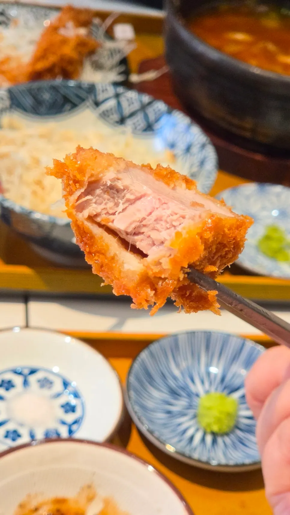 A piece of hire katsu picked up with chopsticks