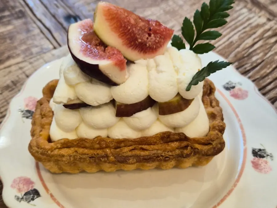 A bite combining pie, cream, and fig together