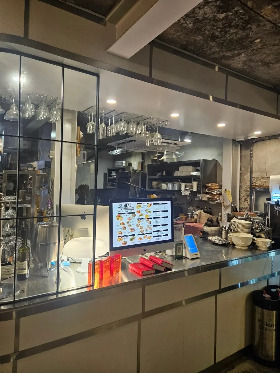 ภายในร้านที่มองเห็นที่นั่งริมหน้าต่างและเทอเรซกลางแจ้ง
