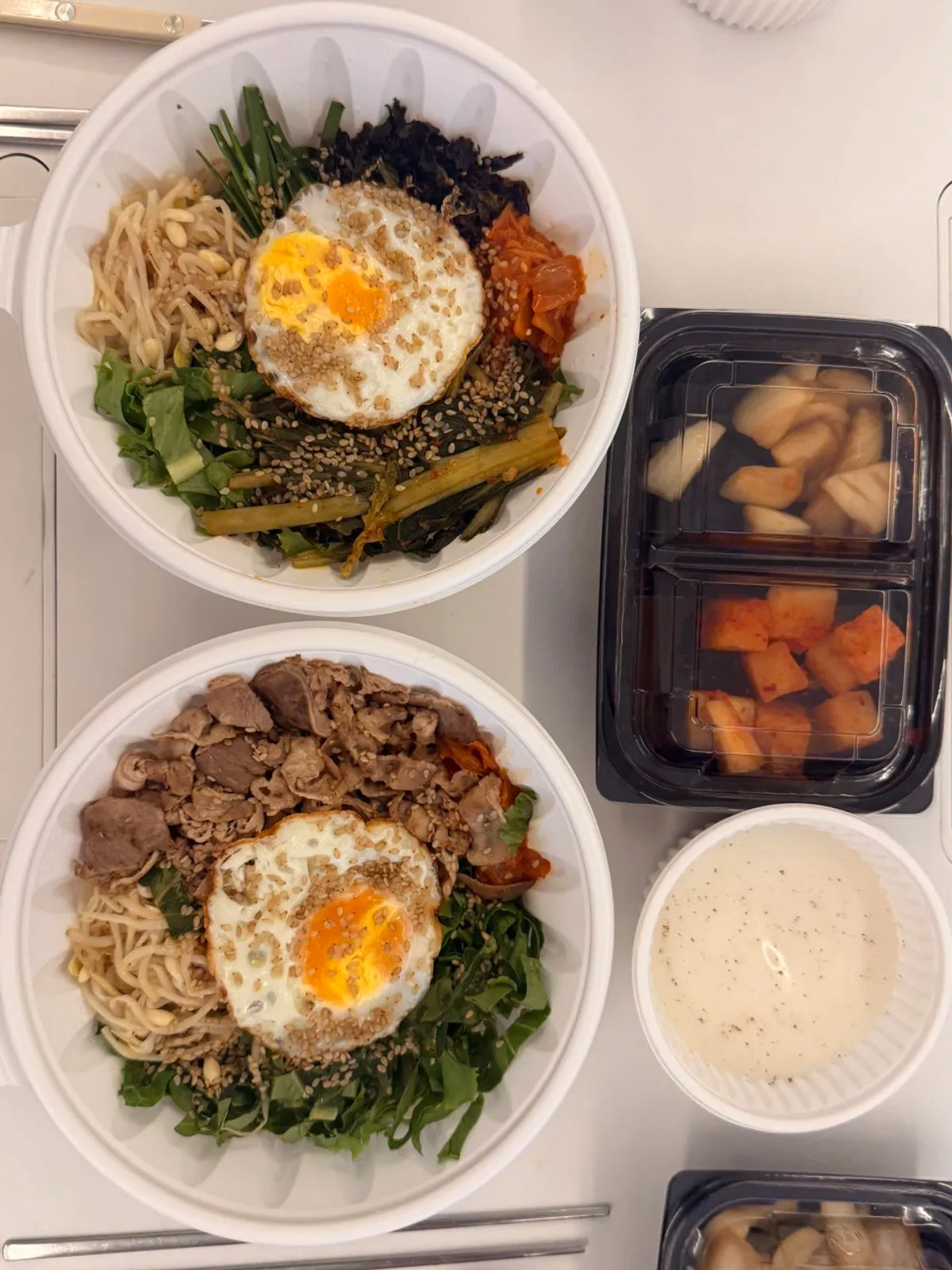 Three takeout Korean dishes laid out at home