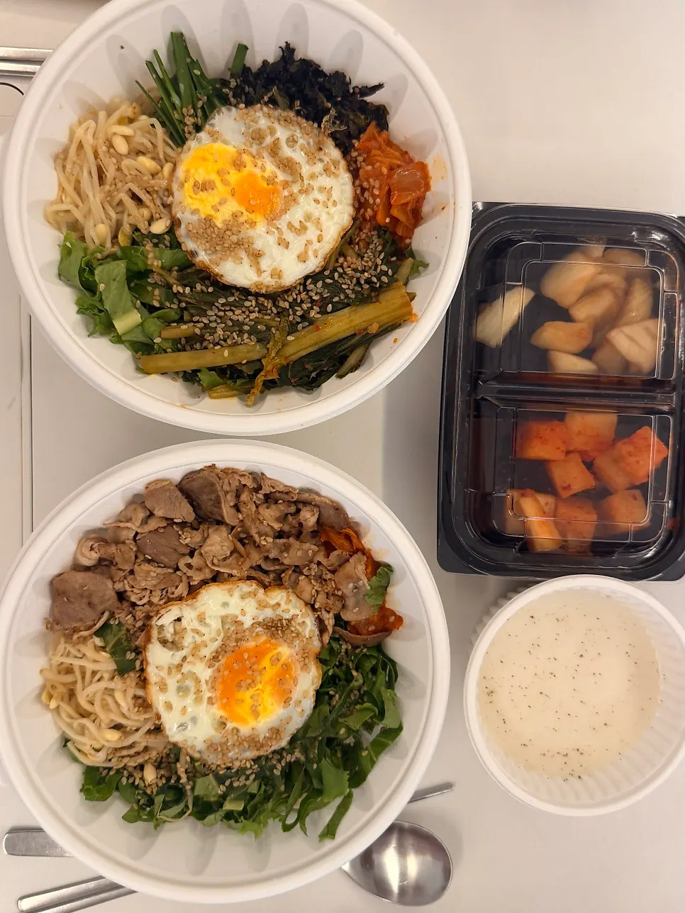 Three ordered dishes being prepared for takeout