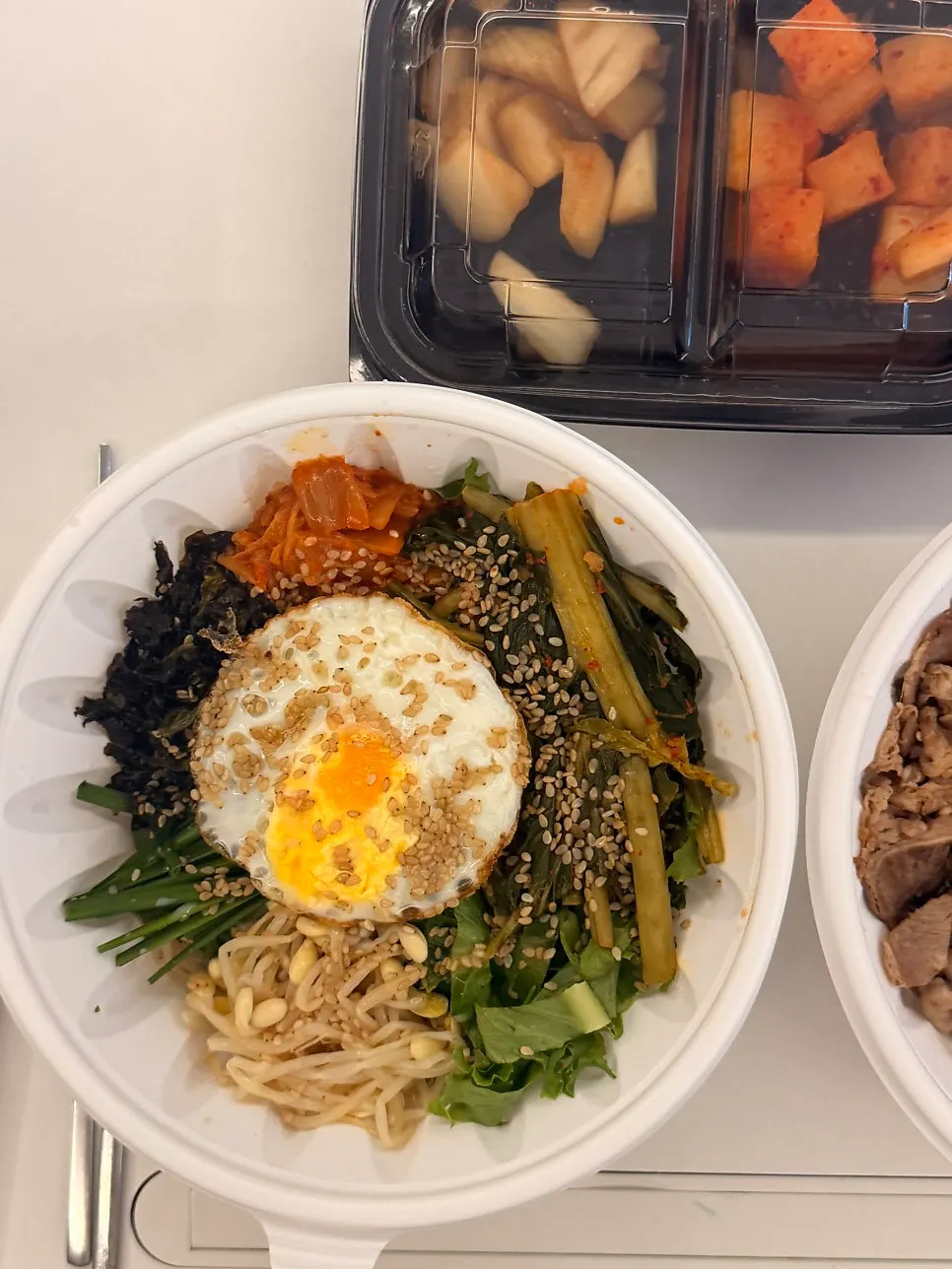 Opened lid on a takeout bibimbap container