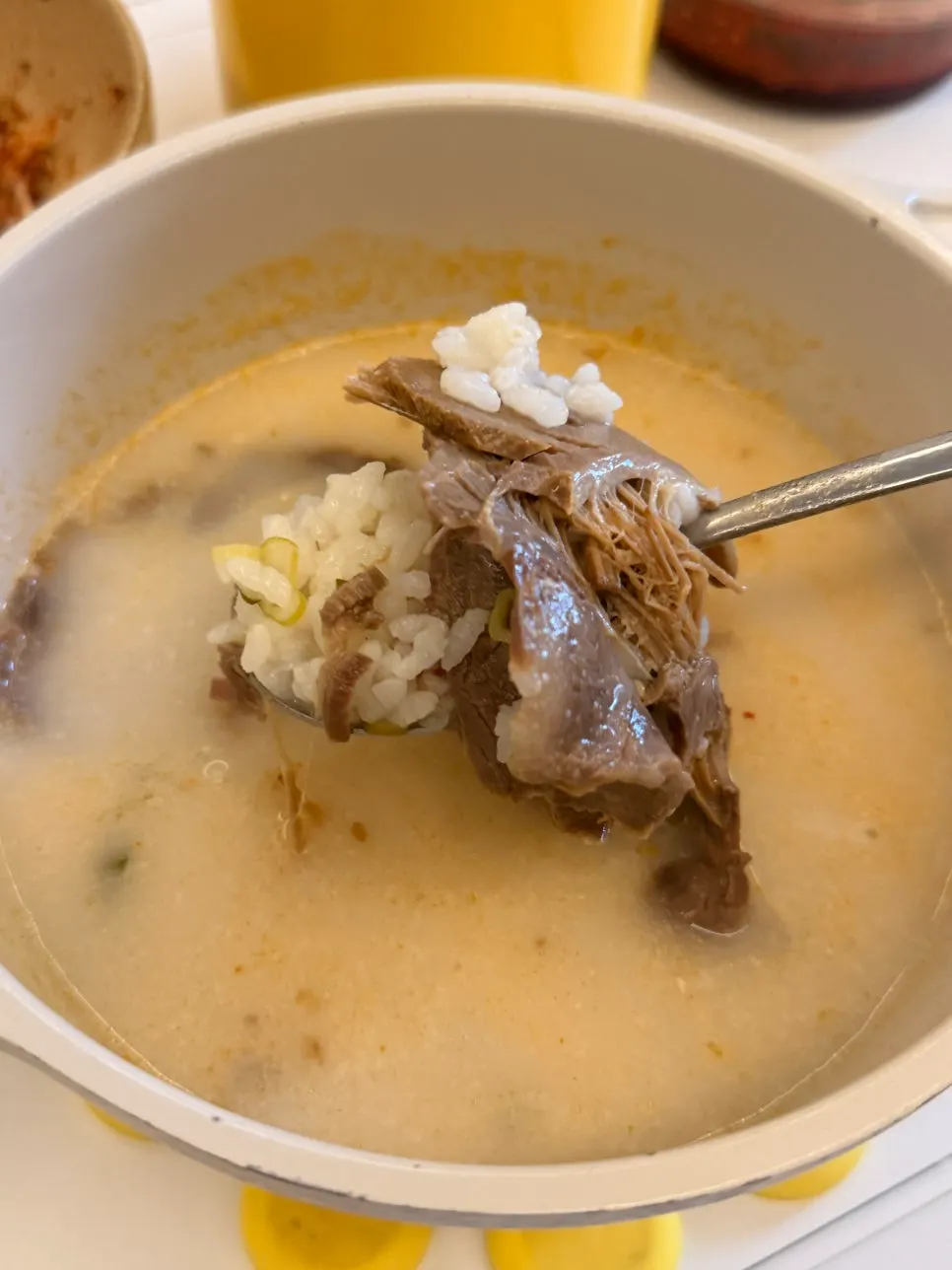 A bowl of bone broth soup with rice and meat on top
