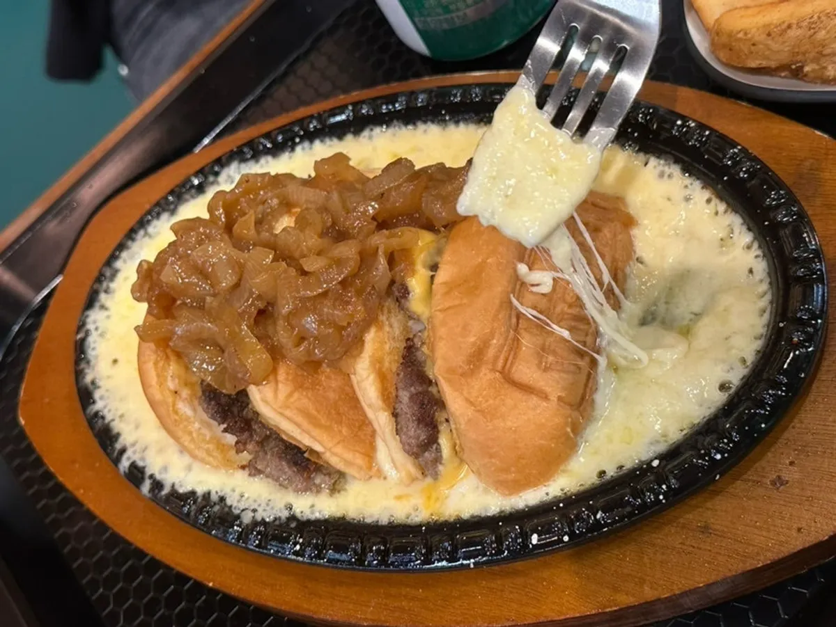 Melted cheese on the skillet with the red skillet cheese burger