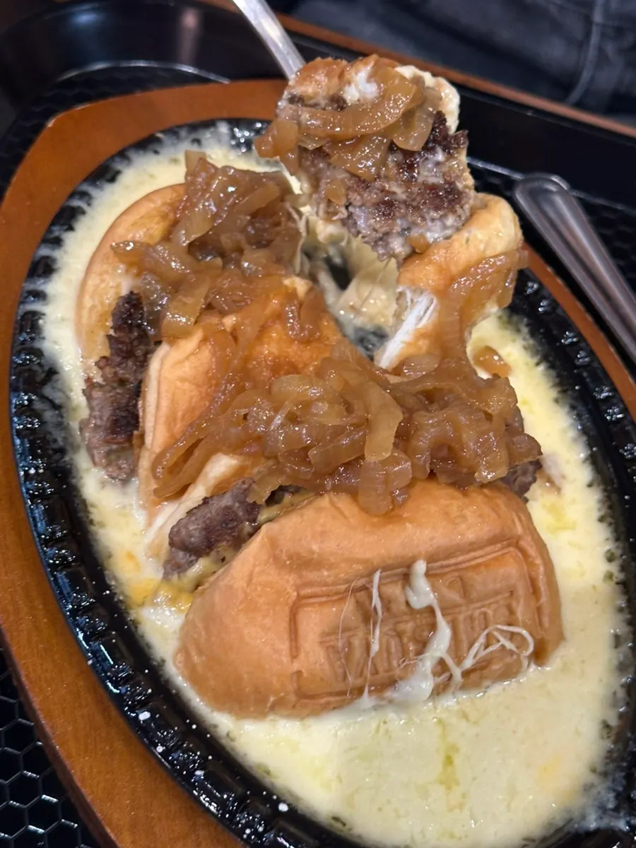 Dipping the burger into the skillet cheese