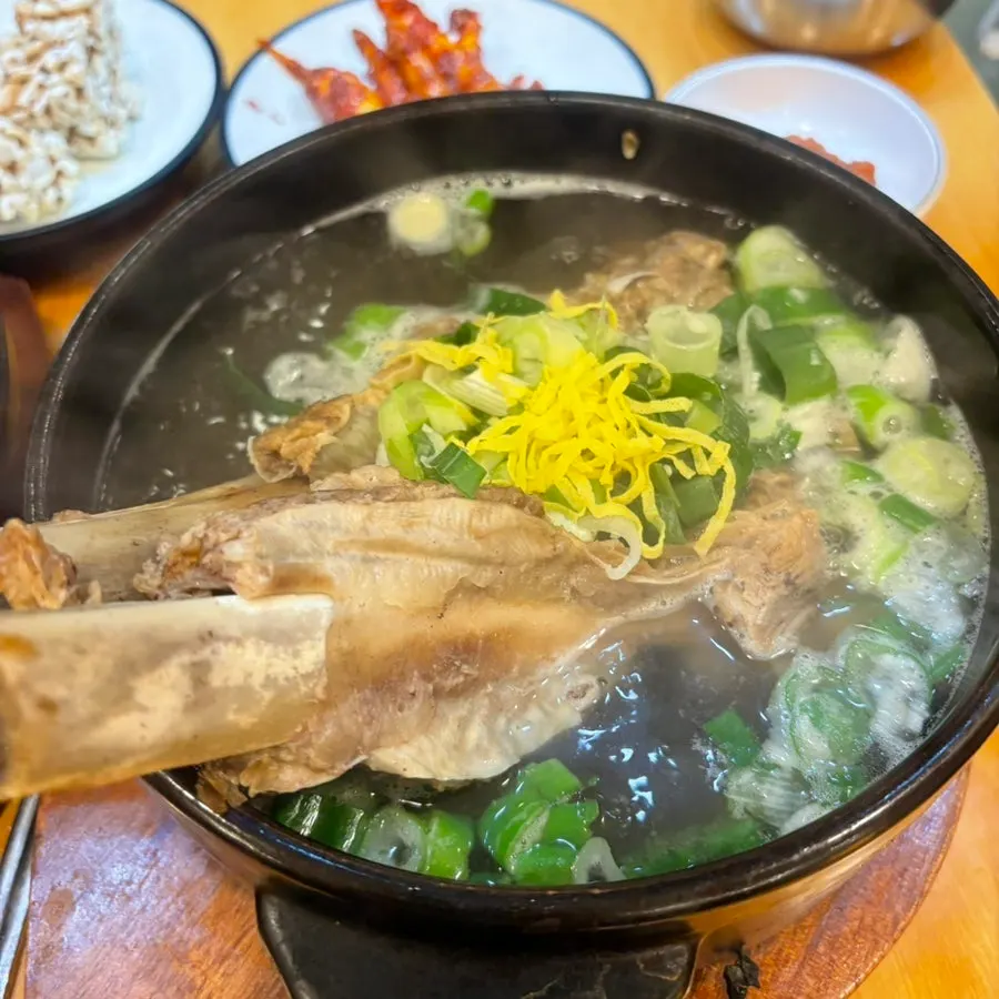A stone bowl of Wongi Hoebok Galbitang topped with a large short rib bone
