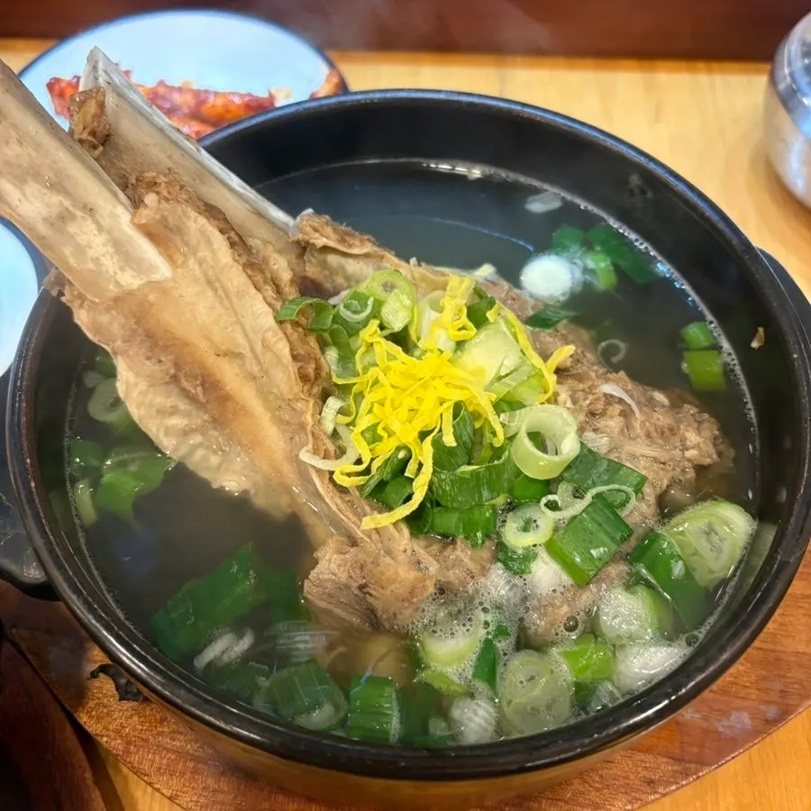 Meat being pulled from the bone with tongs
