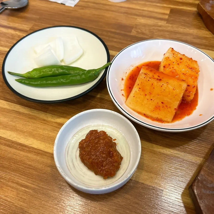 Basic side dishes of seokbakji, peppers, onion, and seasoning sauce