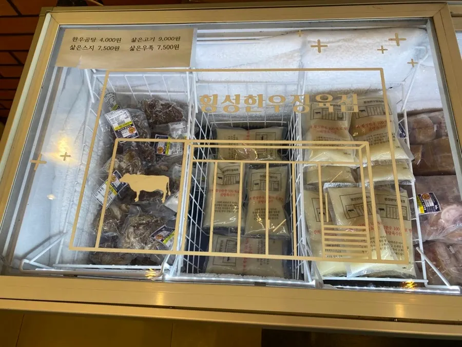 Packaged leg bones and ox feet in the freezer section