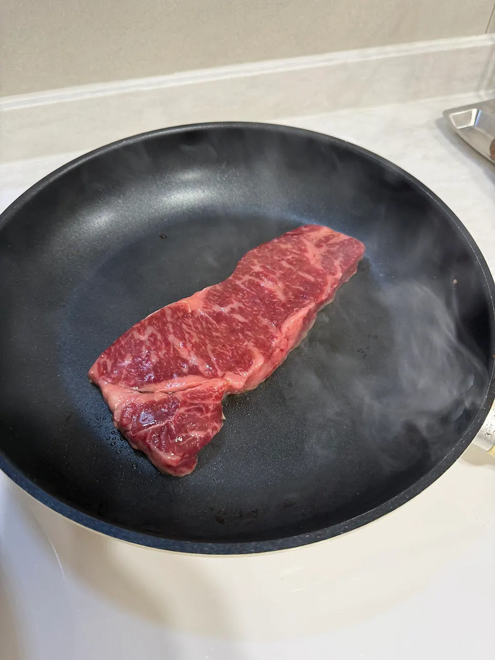 Striploin steak browning in the pan