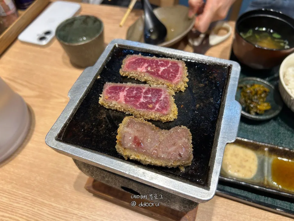 A piece of gyukatsu dipped in sauce