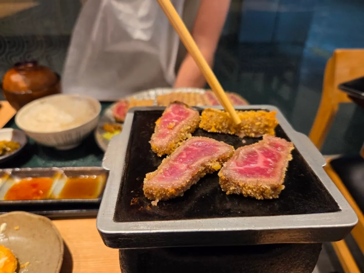 A piece of gyukatsu on the hibachi right before eating