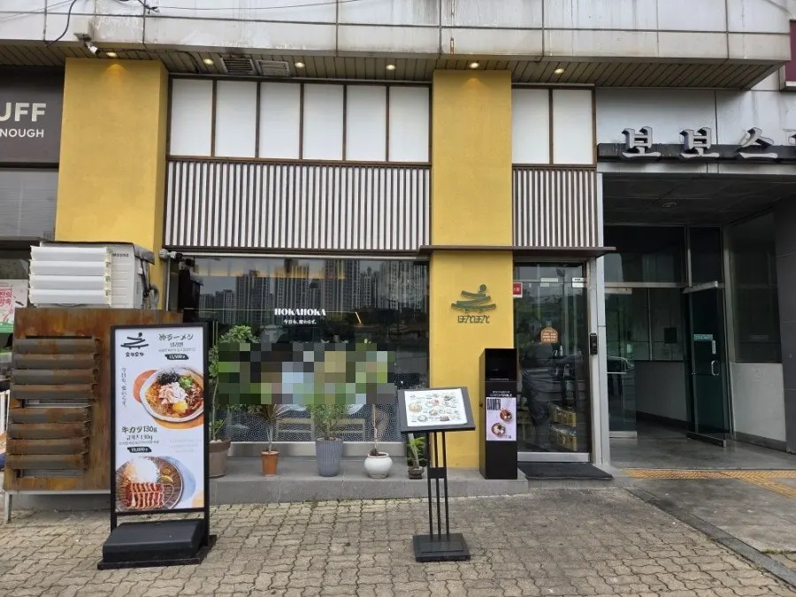 그릇 위에 쉼표가 있는 호카호카 로고 간판