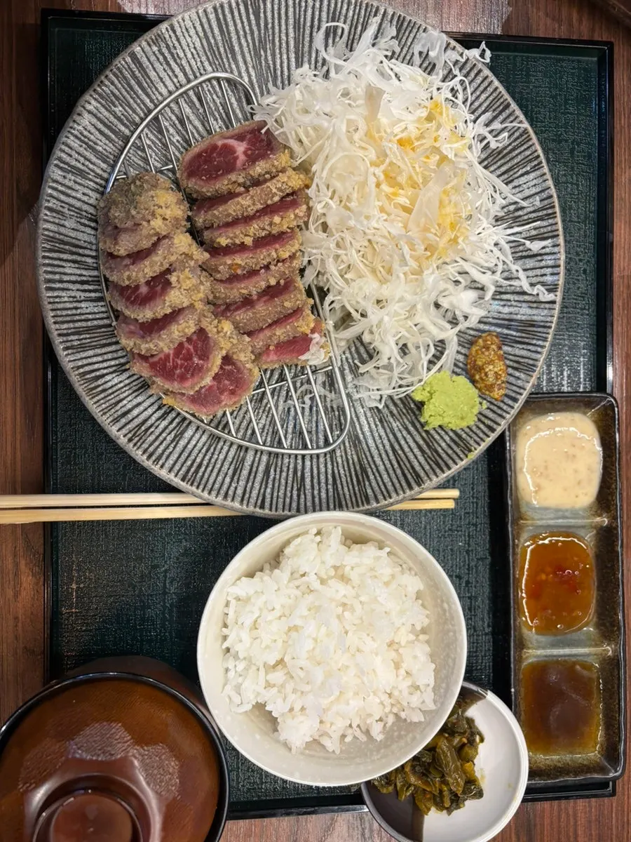 Sliced cabbage and sauces served alongside the gyukatsu