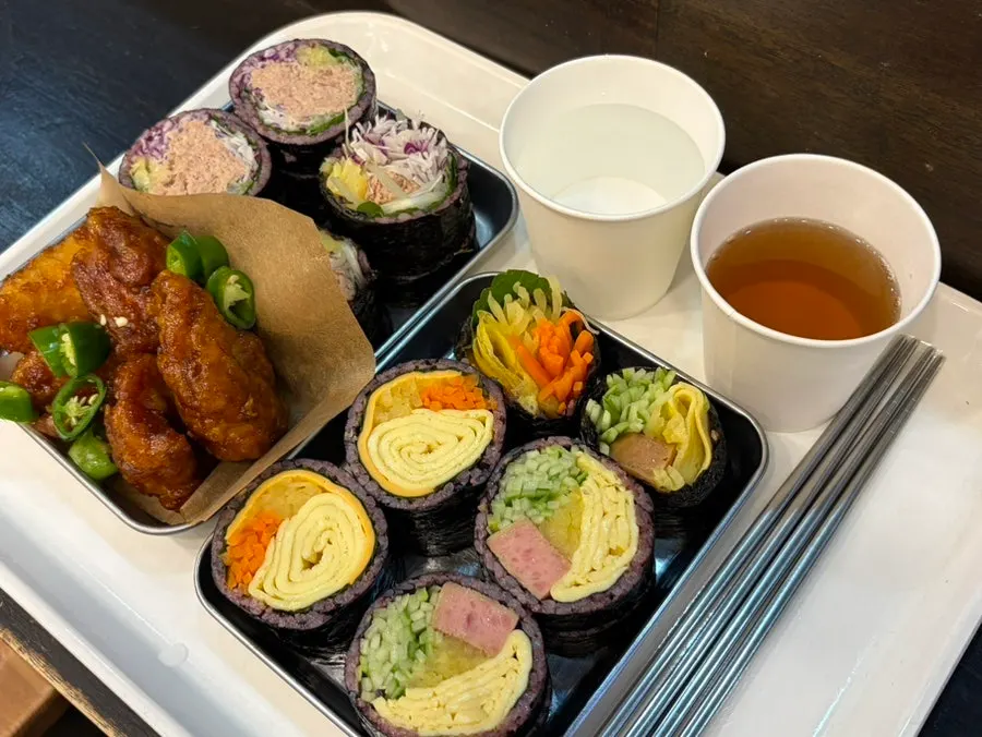 A half-and-half spread of three gimbap types plus a dakgangjeong set