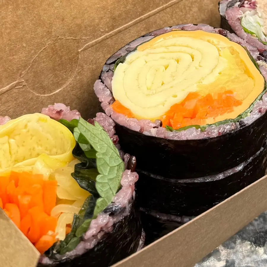 Cross-section of double cheese egg gimbap with cheese and egg