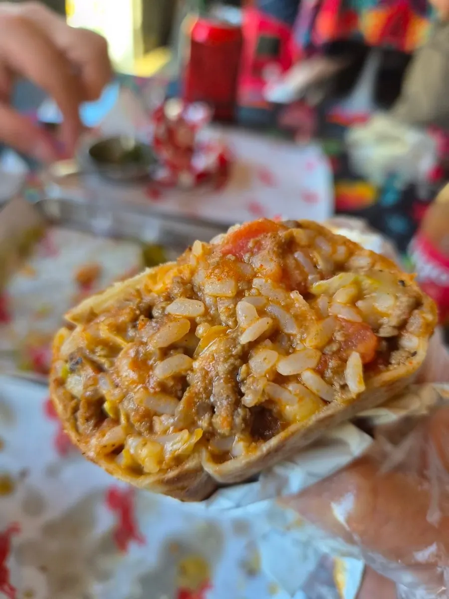 Cross-section of a chili burrito with sauce