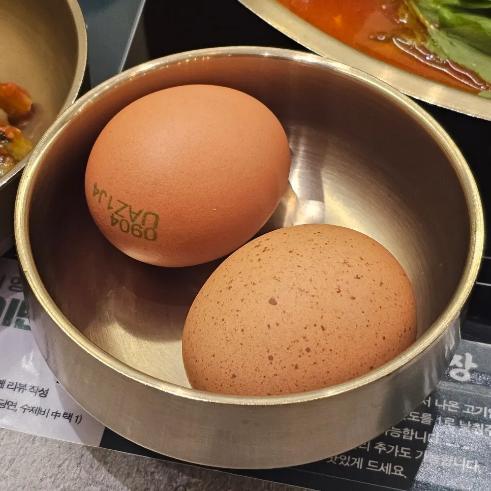 Two raw eggs served to add into the hot pot