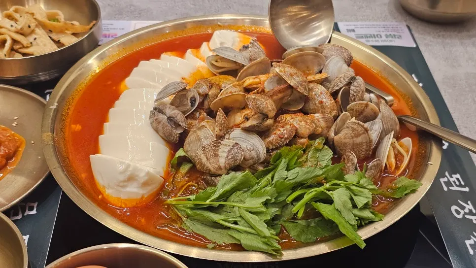 Hot pot filled with sundubu, clams, and minari