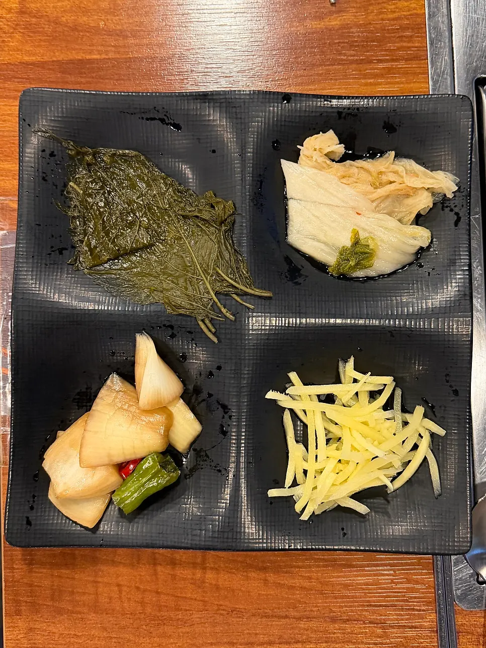 Table setting with perilla leaves, white kimchi, and other basic side dishes