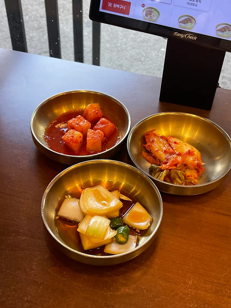 Three side dishes: kkakdugi, kimchi, and pickled onions